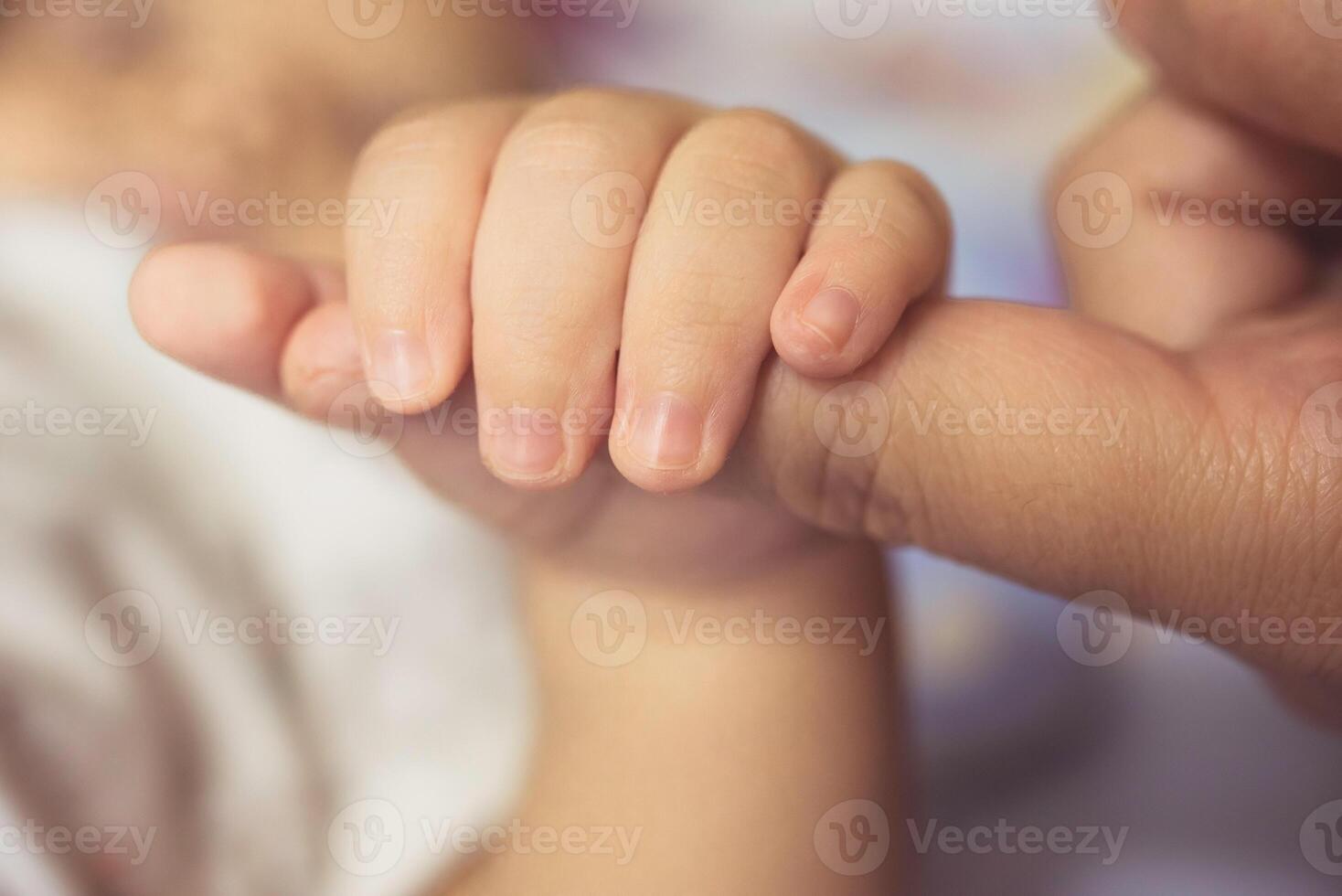 das Hände von das Mutter halt das Babys Hand mit Liebe und fürsorglich. foto