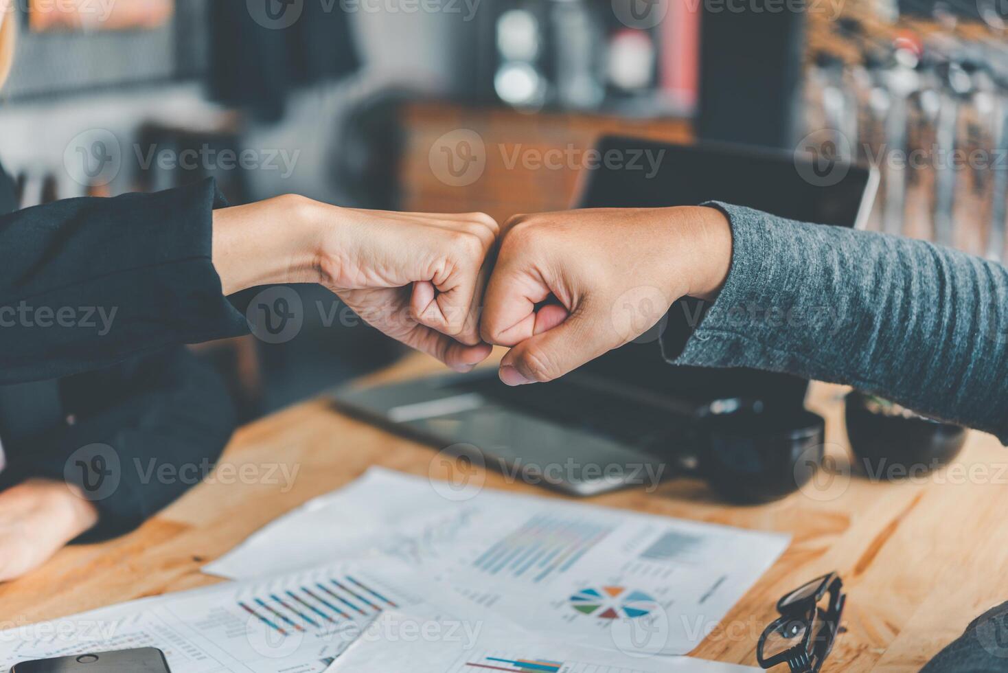 Geschäft Kollegen Herstellung ein Faust Bump sind glücklich zu Arbeit zusammen erfolgreich , Arbeiten im ein zuverlässig Mannschaft foto