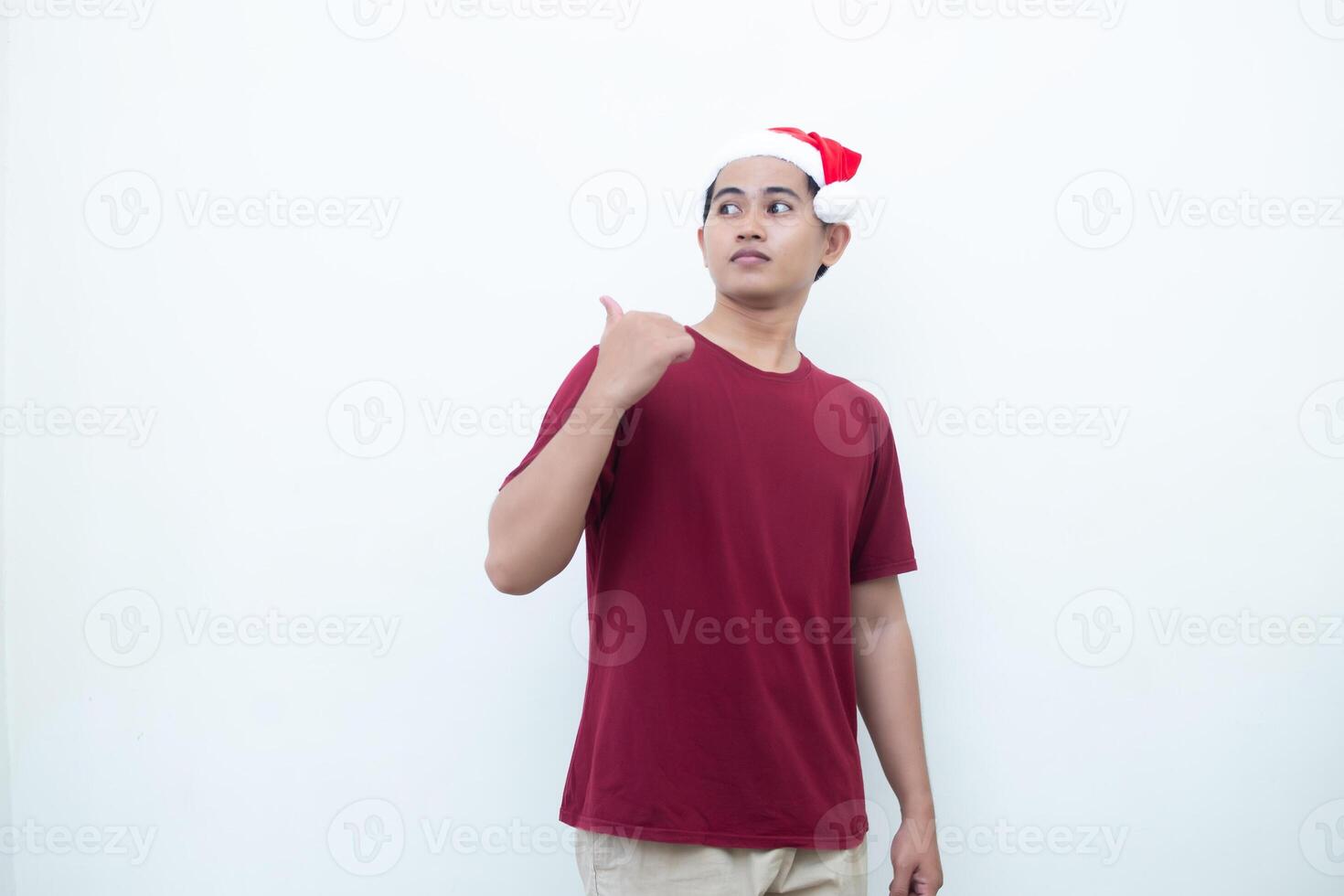 jung asiatisch Mann tragen ein Santa claus Hut lächelnd, Schock und zeigen zu ihr Seite isoliert durch Weiß Hintergrund zum visuell Kommunikation foto