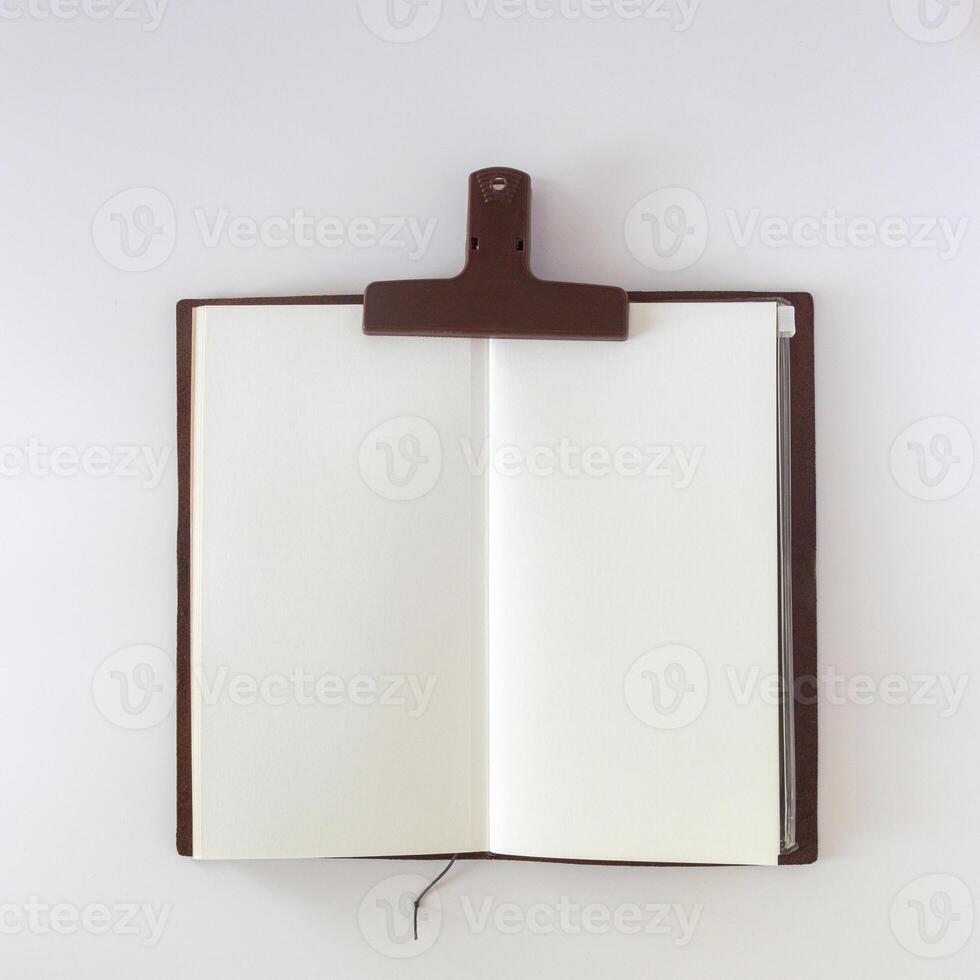 öffnen Weiß leer auf Weiß Hintergrund mit Plastik Papier Clip. Reise Notizbuch oder Skizzenbuch. foto