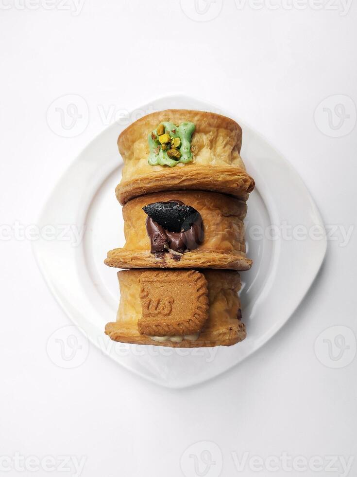 Cromboloni, Neu York rollen Croissant mit ein Vielfalt von Soße Beläge, serviert auf ein Weiß Teller und isoliert Weiß Hintergrund. foto