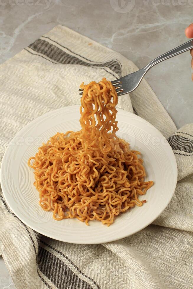 Essen gebraten Nudel indomie Goreng, nehmen Nudeln mit Gabel. foto