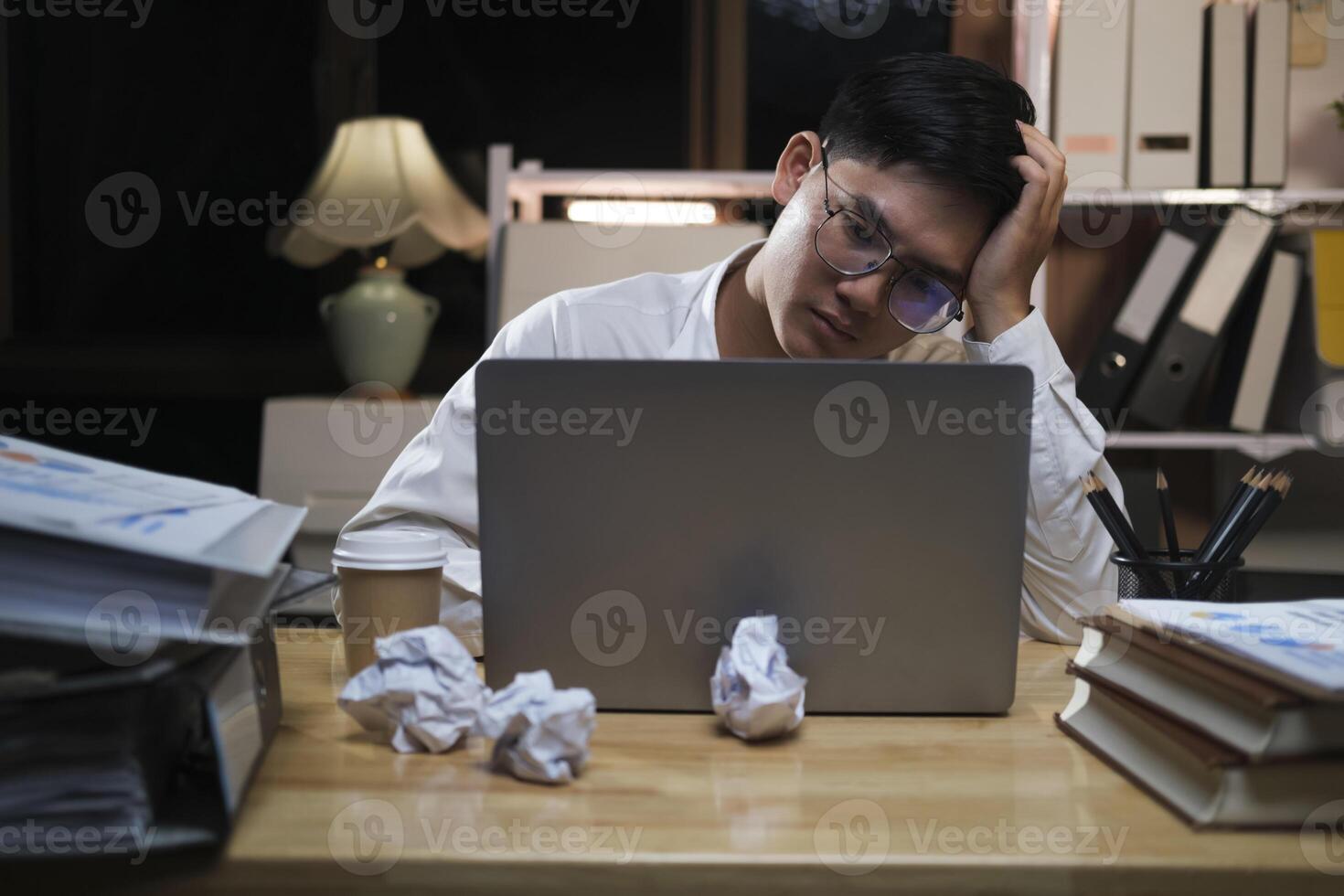 asiatisch jung müde Mitarbeiter Geschäftsmann mit Desktop Computer haben Überarbeitung Projekt über Nacht im Büro. foto