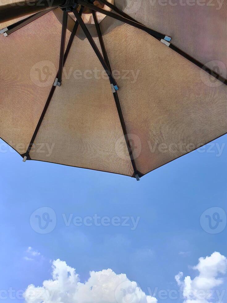 niedrig Winkel Aussicht von ein geöffnet Strand Stoff Regenschirm gegen das Blau sonnig Himmel, Aussicht von unter Sonnenschirm, Urlaub oder Ferien Konzept, mit Kopieren Raum foto