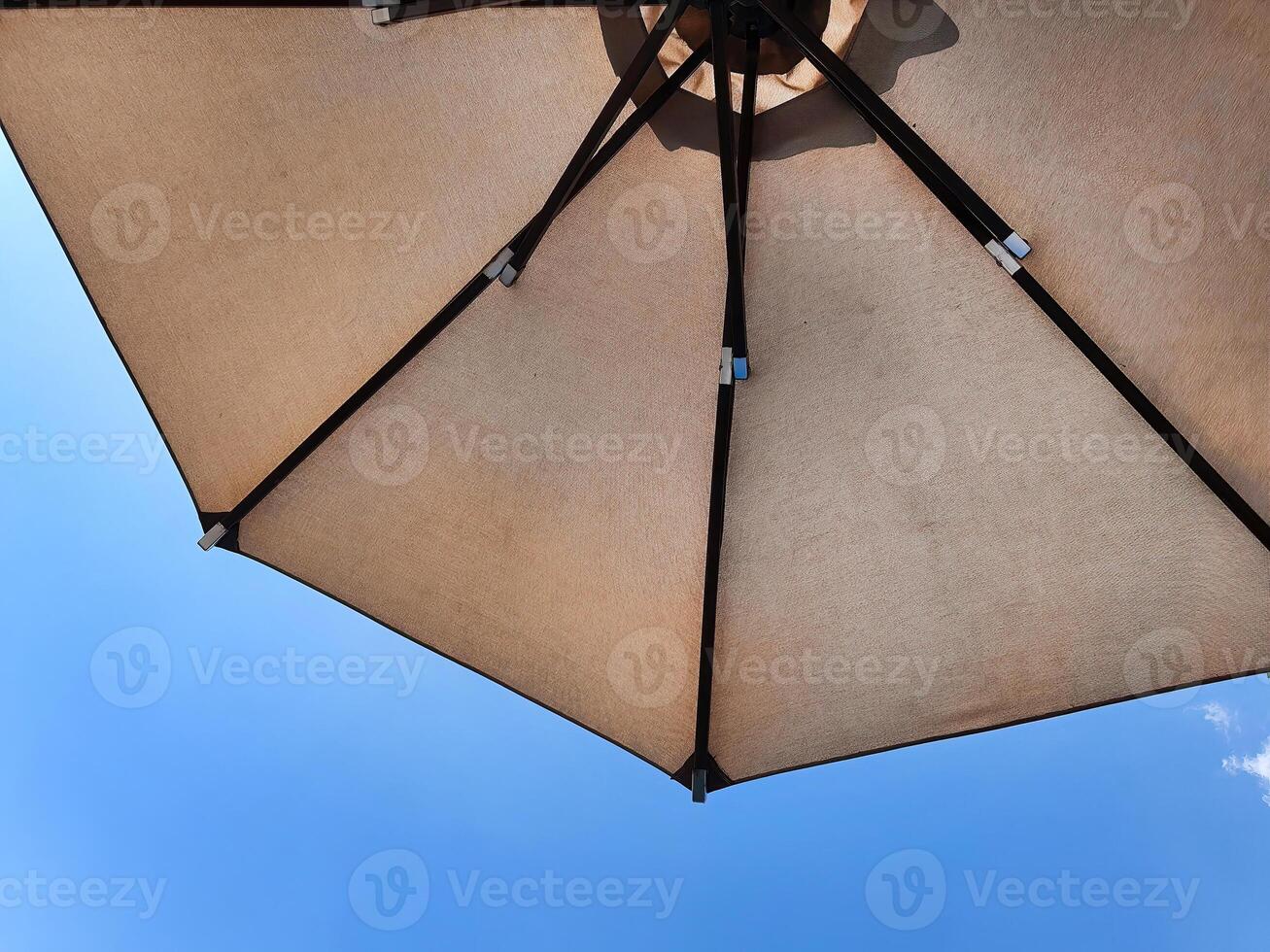 niedrig Winkel Aussicht von ein geöffnet Strand Stoff Regenschirm gegen das Blau sonnig Himmel, Aussicht von unter Sonnenschirm, Urlaub oder Ferien Konzept, mit Kopieren Raum foto