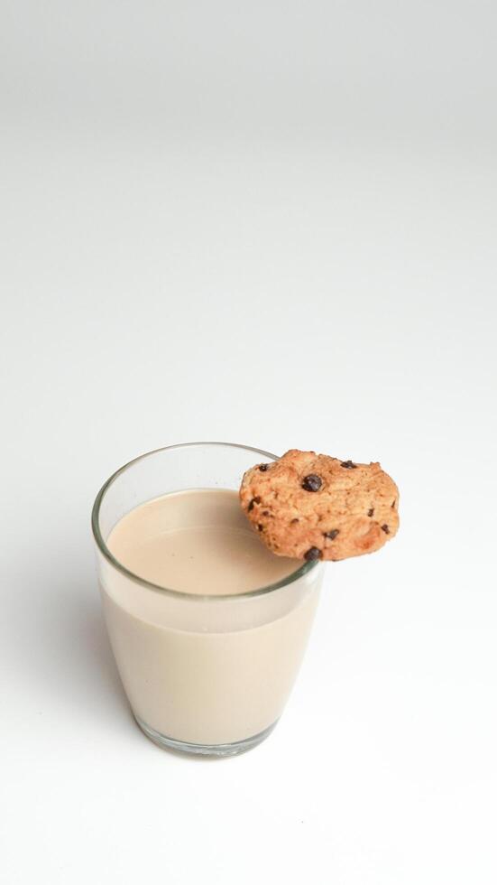 Schokolade Chip Kekse und ein Glas von Milch Kaffee auf ein Weiß Hintergrund foto