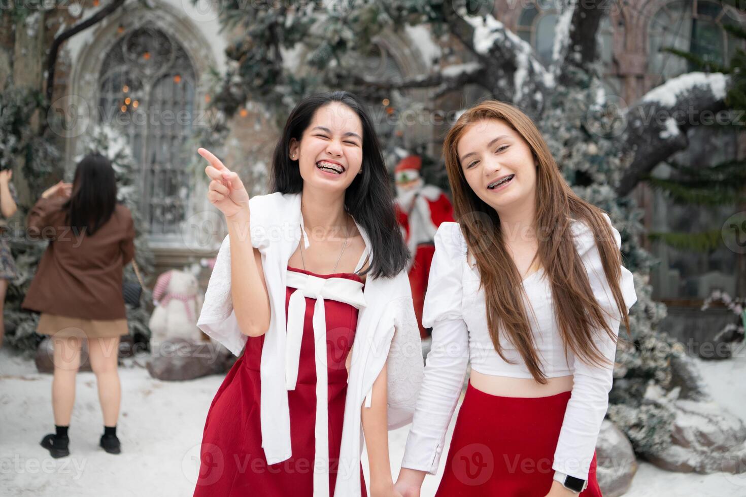 Porträt von Teenager Mädchen im ein rot Kleid entspannt und lächelnd im ein schneebedeckt Hof. foto