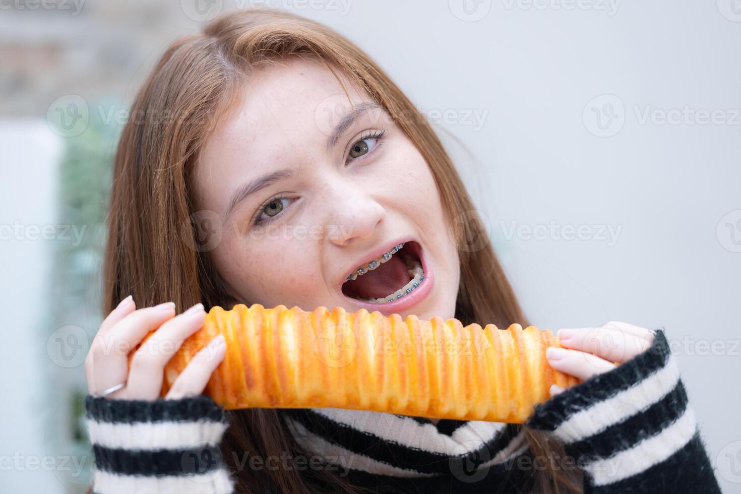 Porträt von Teenager Mädchen Essen Brot im das Küche beim Zuhause foto