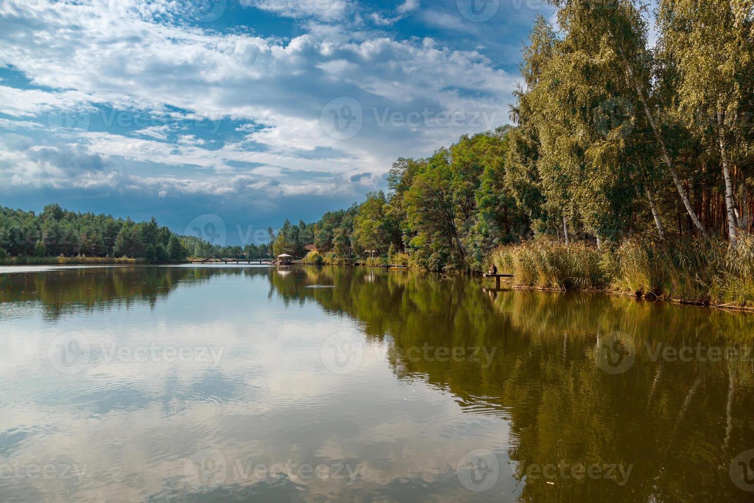 schön Aussicht von das See mit Blau Himmel, Wolken, und Grün Bäume foto