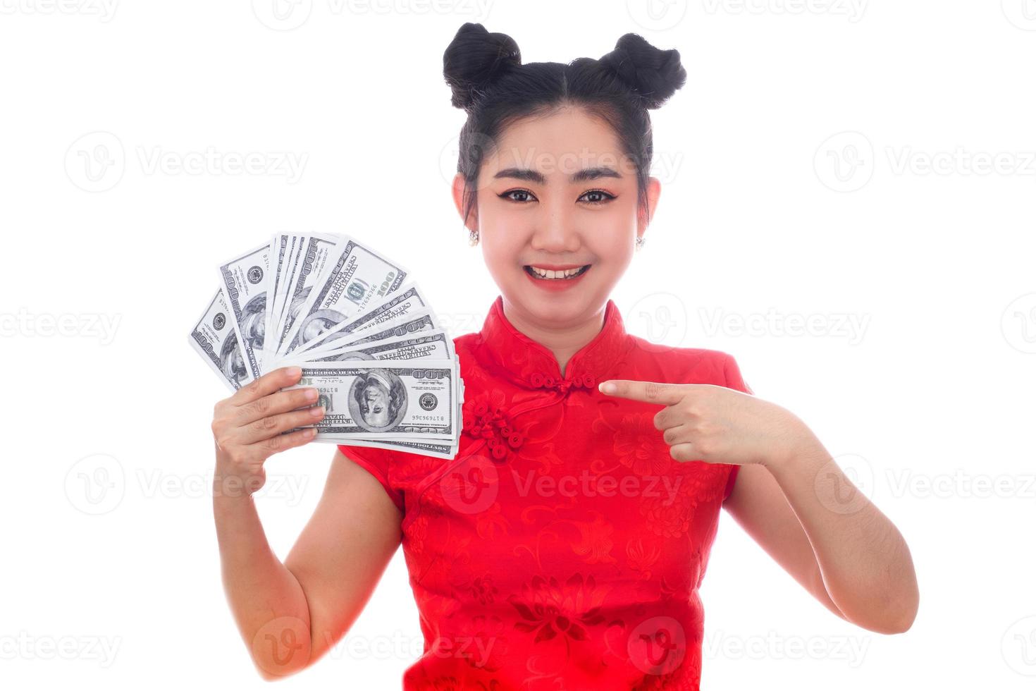 Porträt asiatische Frau rotes Kleid traditionelles Cheongsam hält Geld 100-US-Dollar-Scheine auf weißem Hintergrund foto