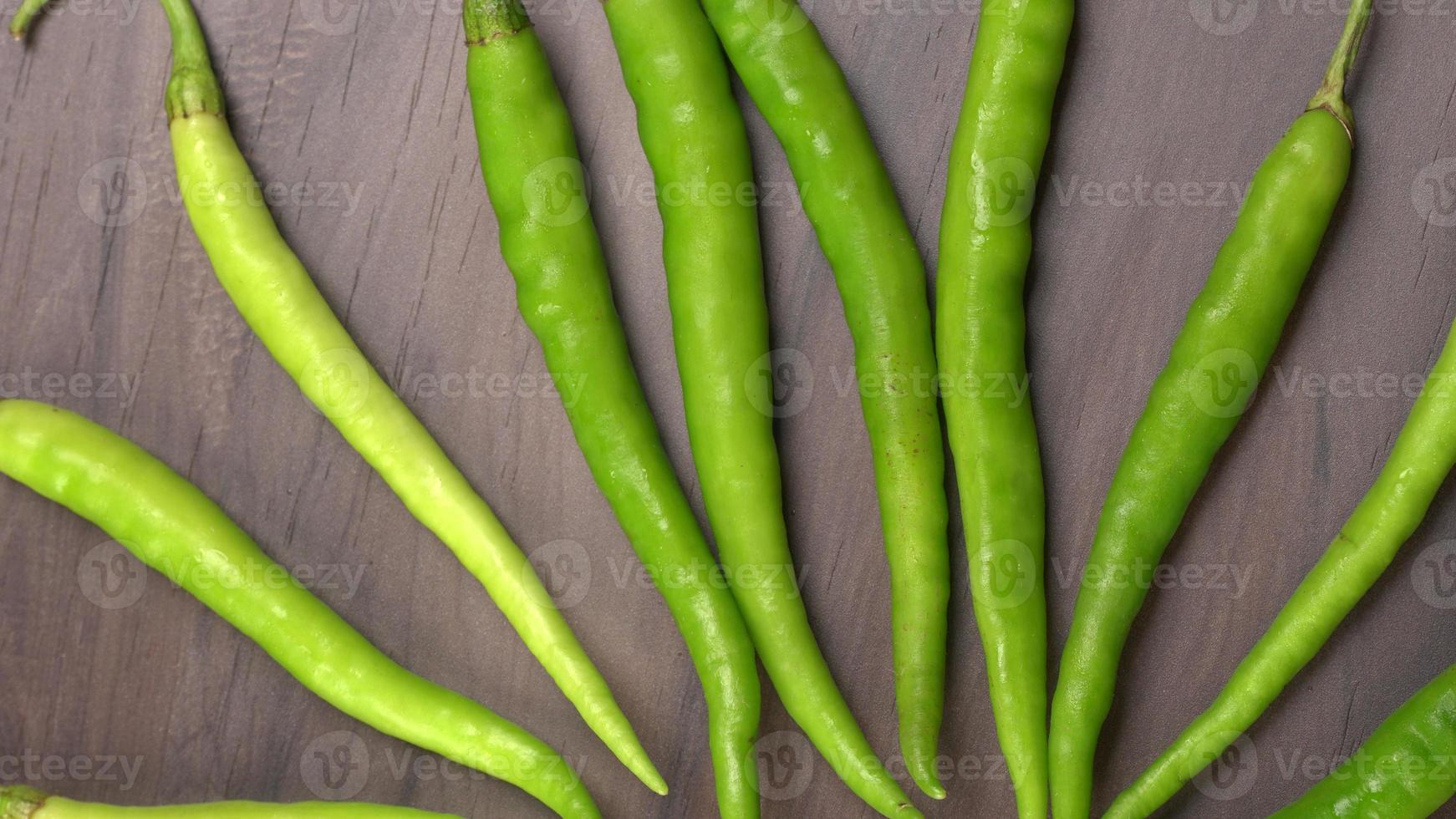 Frische lange indische grüne Chilis auf Holzhintergrund. foto