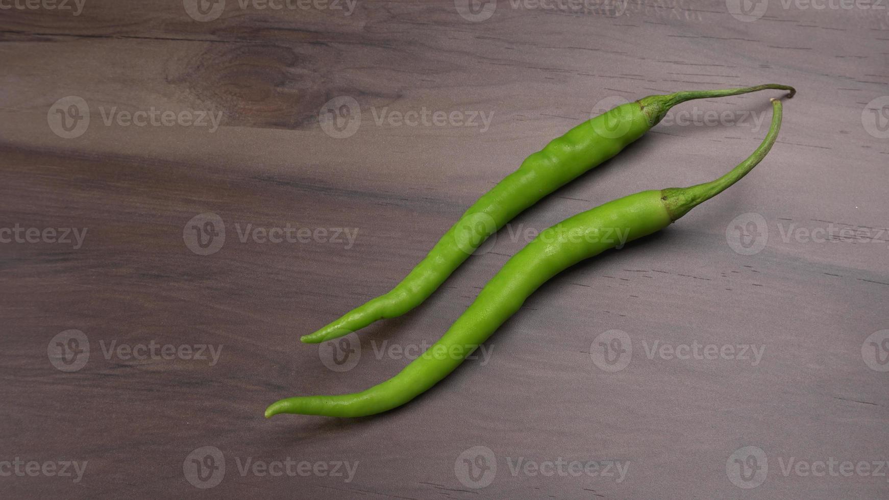 Frische lange indische grüne Chilis auf Holzhintergrund. foto