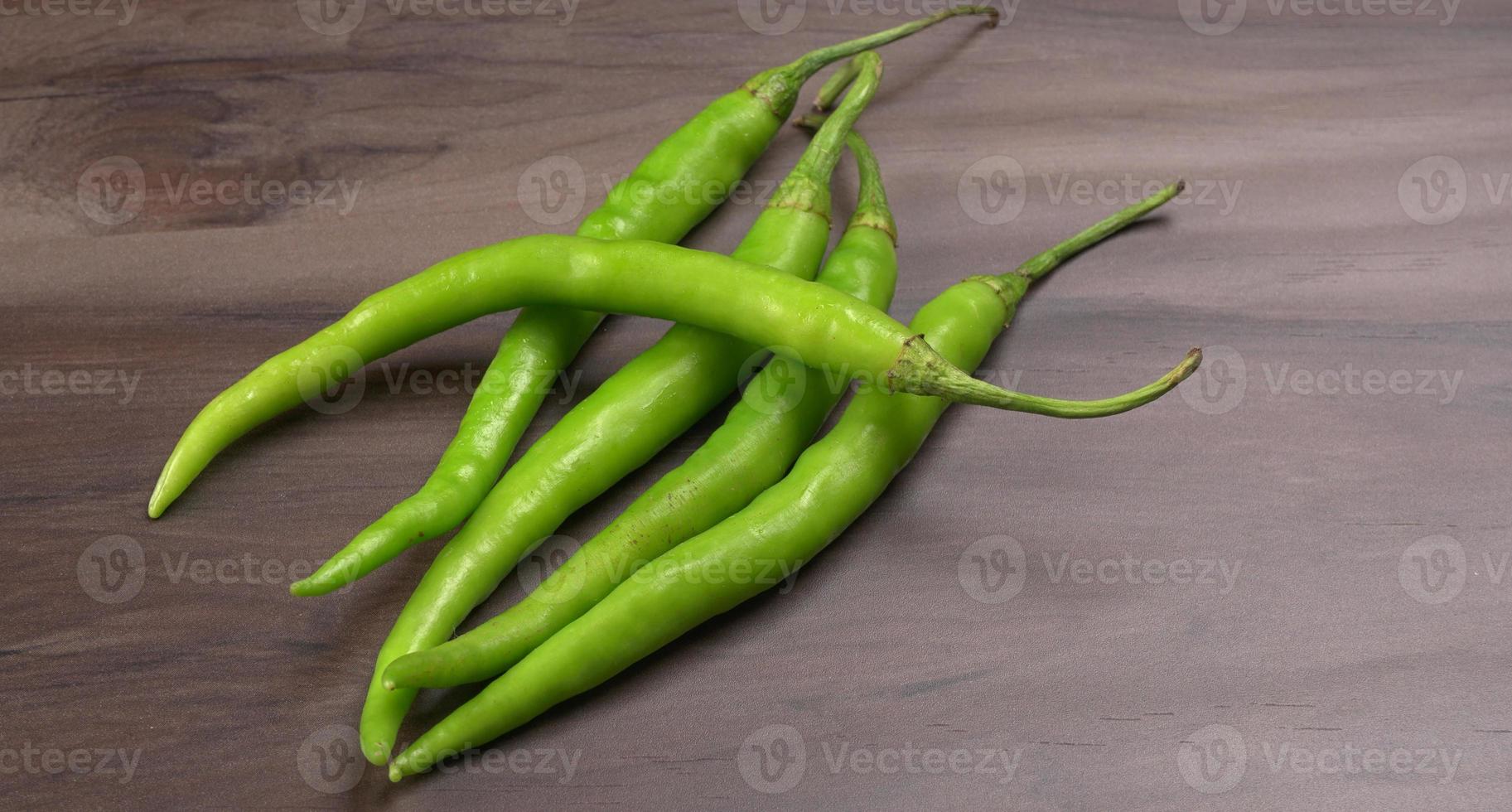 Frische lange indische grüne Chilis auf Holzhintergrund. foto