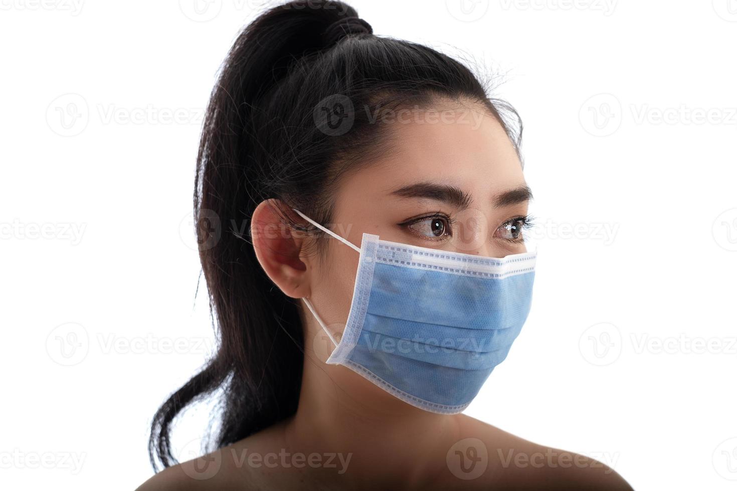schöne junge asiatische frau, die eine medizinische maske aufsetzt, um vor atemwegserkrankungen wie der grippe covid-19 pm2.5 staub und smog zu schützen, frauensicherheitsvirusinfektionskonzept foto