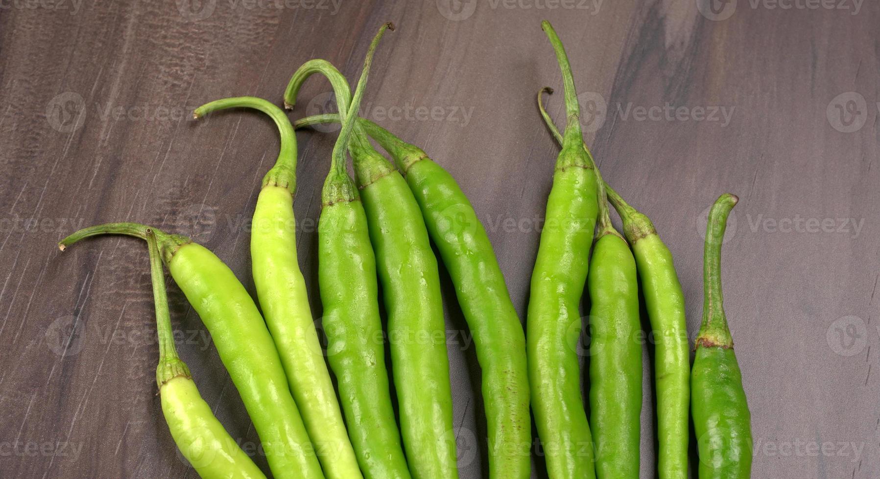 Frische lange indische grüne Chilis auf Holzhintergrund. foto