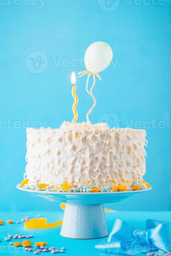 dekorativer Kuchen beleuchtete Kerze blauer Hintergrund foto