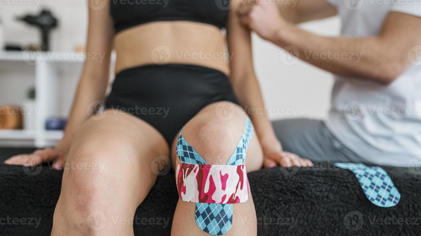 Physiotherapie der Patientin mit Kniebandage foto