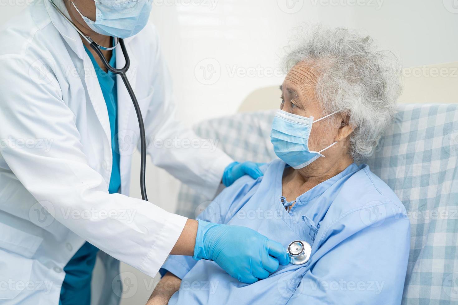 Arzt hilft asiatischen Senioren oder älteren Patienten, die im Krankenhaus eine Gesichtsmaske tragen, um die Sicherheitsinfektion zu schützen und das Covid-19-Coronavirus abzutöten. foto