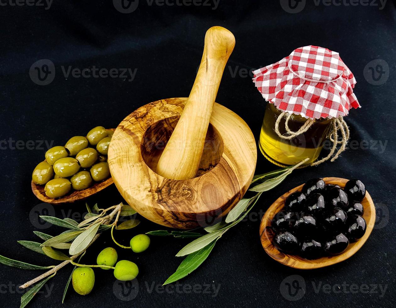 kaltgepresstes Olivenöl mit Zweigen und Früchten foto