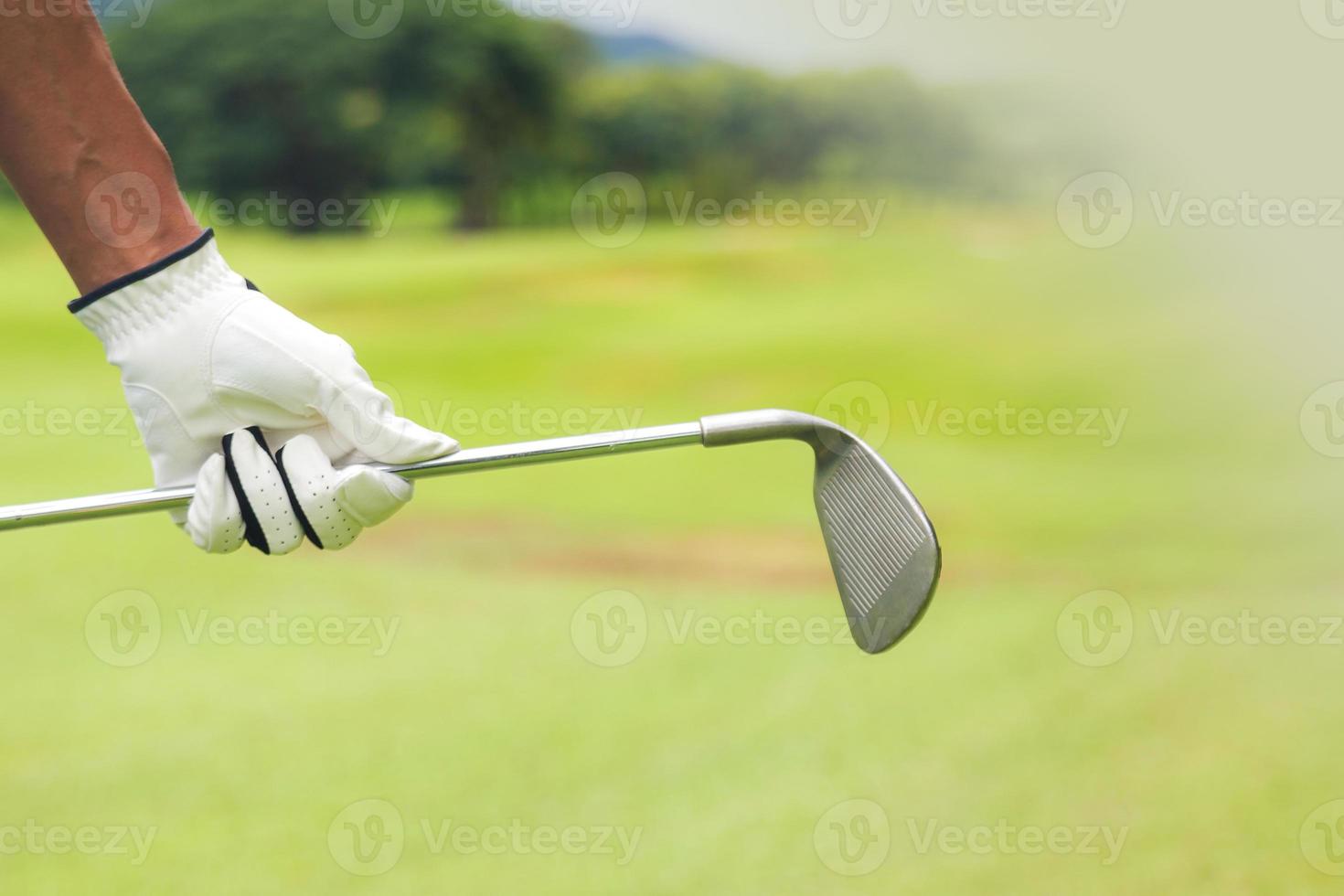 Golfspieler, der einen Golfschläger auf dem Golfplatz hält foto