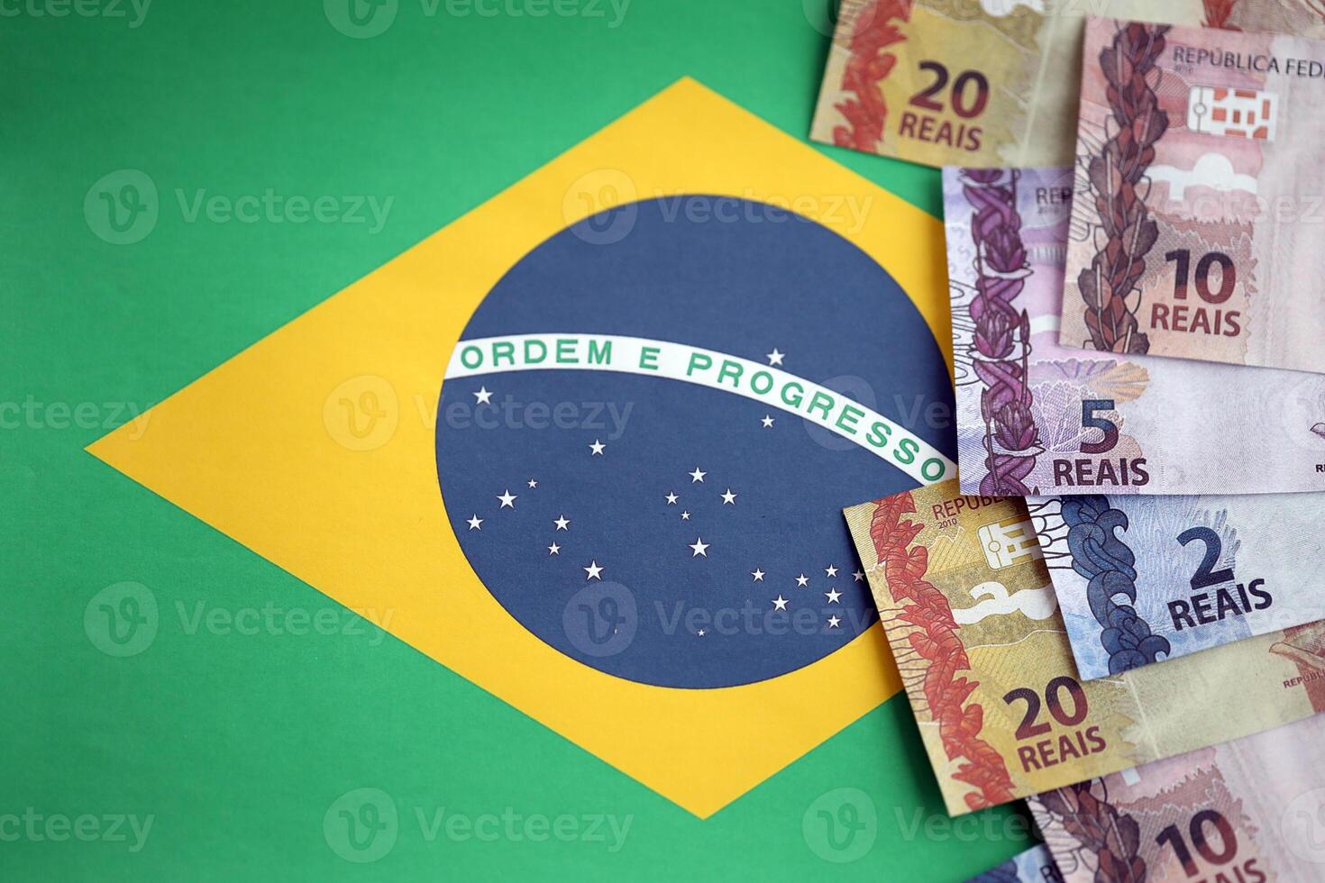 Brasilianer Geld Rechnungen auf oben von das National Flagge von föderativ Republik von Brasilien foto