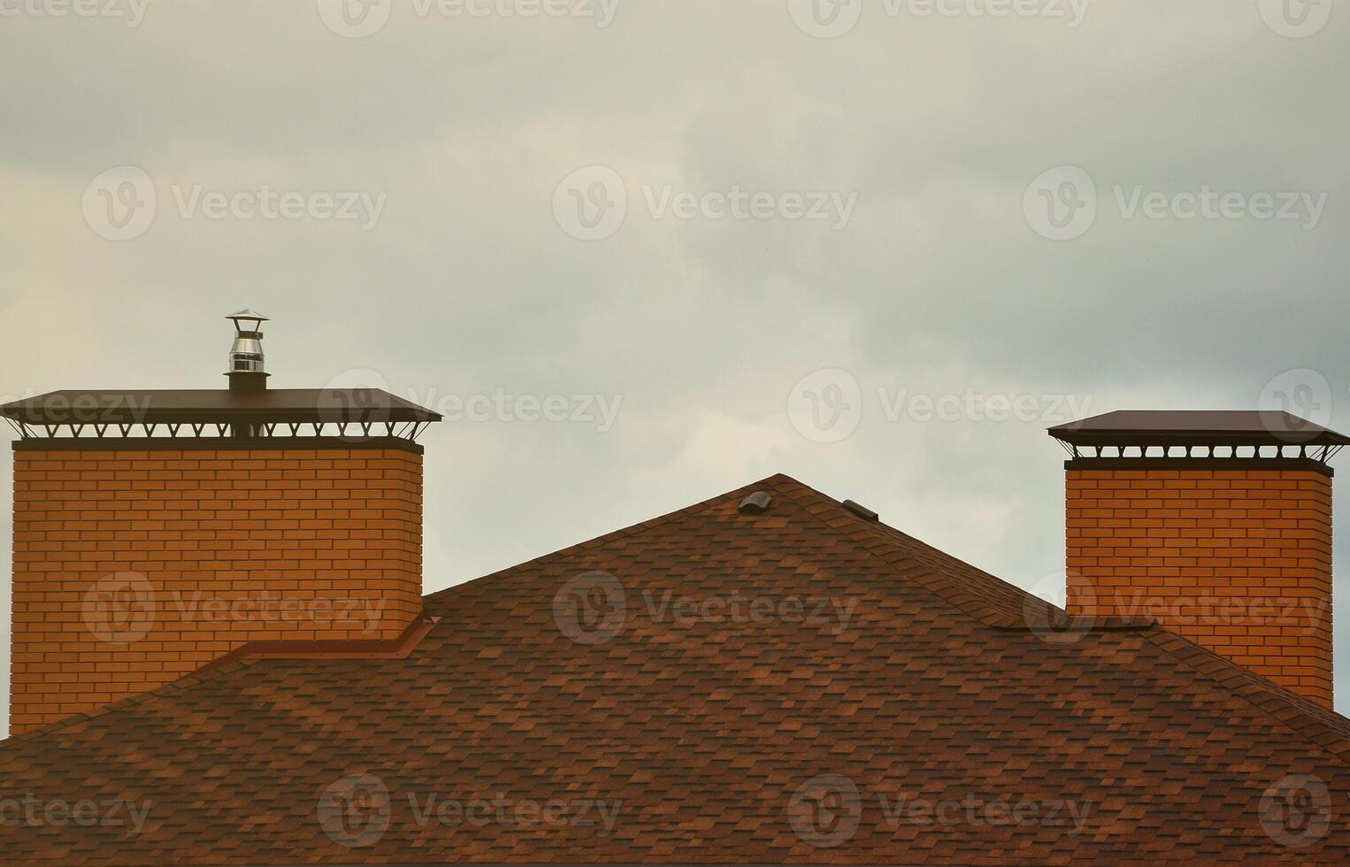 Das Haus ist mit einer hochwertigen Dacheindeckung aus Schindeln aus Bitumenziegeln ausgestattet. ein gutes Beispiel für eine perfekte Überdachung. Das Dach ist zuverlässig vor Witterungseinflüssen geschützt foto