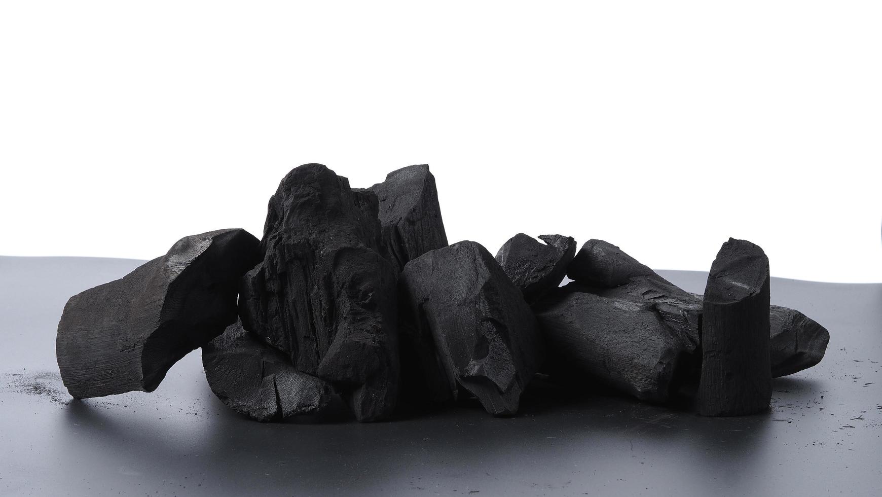 Holzkohle. schwarze Holzkohle auf schwarzem strukturiertem Boden. zum Kochen verwendet foto