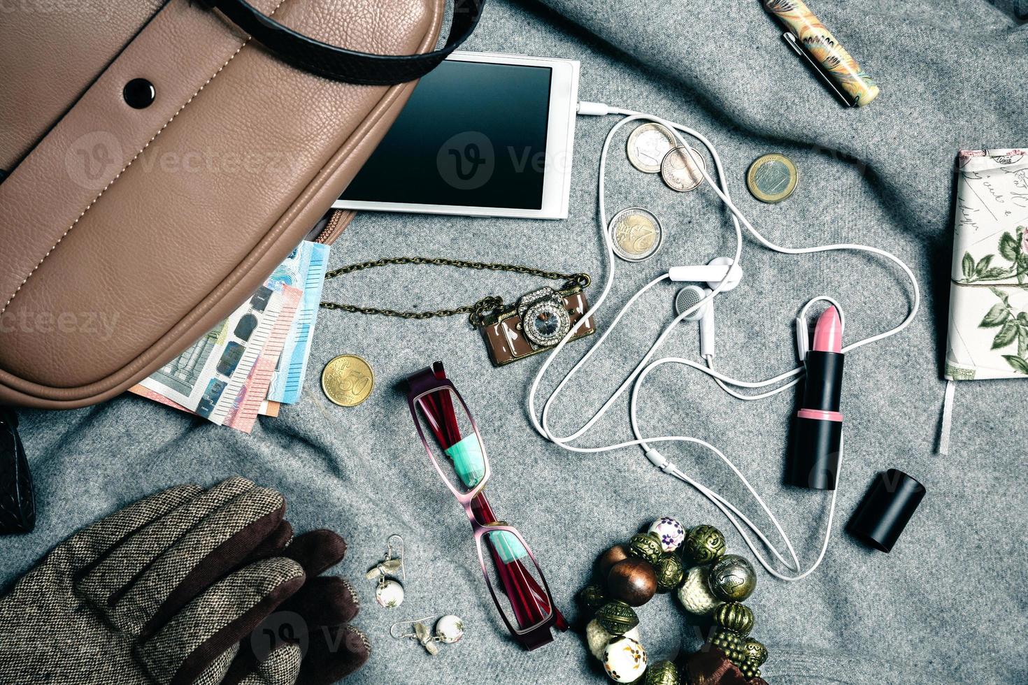 feminine Accessoires aus Damenhandtasche auf grauem Hintergrund foto