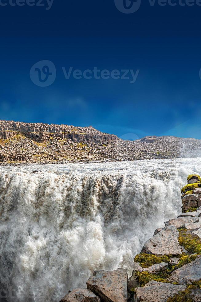 Blick über den größten und mächtigsten Wasserfall Europas namens Dettifoss in Island, in der Nähe des Myvatn-Sees, bei blauem Himmel, Sommer foto