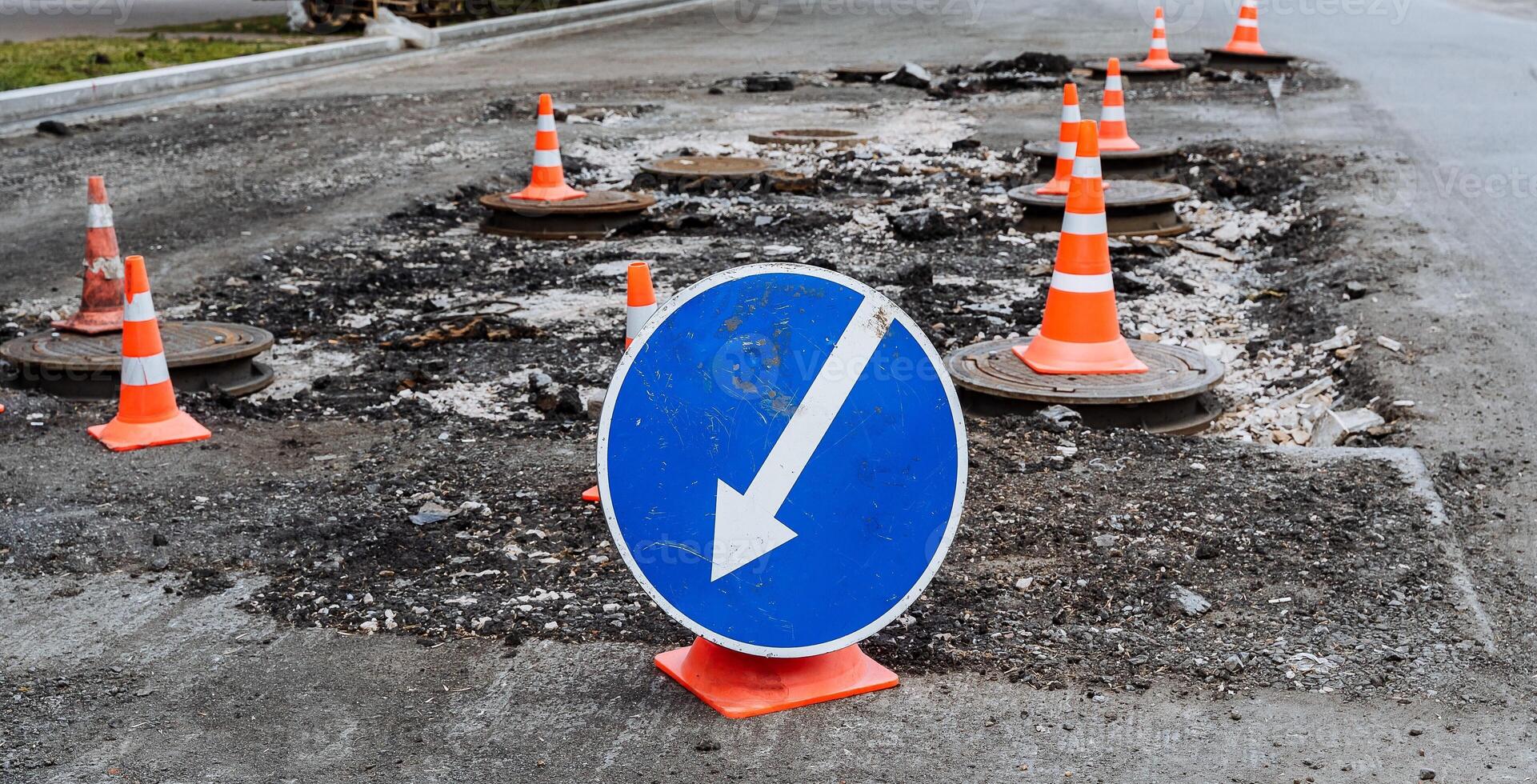 Straße Zeichen ein Weiß Pfeil auf ein Blau Hintergrund zeigt an das Weg, Straße funktioniert, Umleitung von ein gefährlich Sektion von Straße, Reparatur von das Straßenbett foto