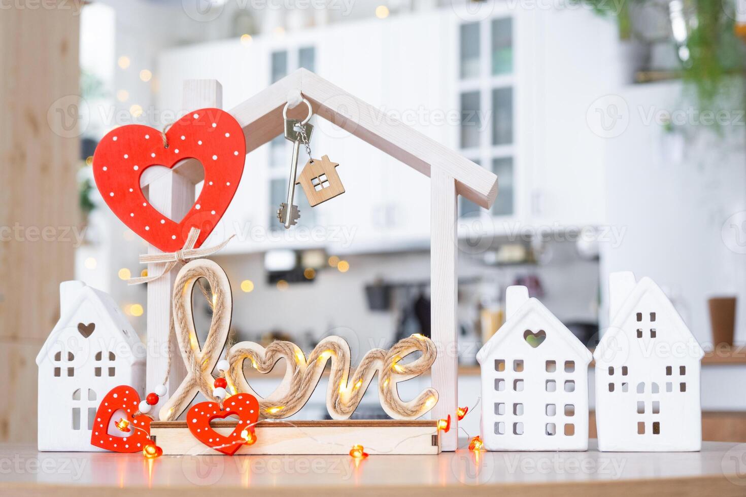 Schlüssel zu winzig Haus von gemütlich Zuhause mit Valentinstag Dekor auf Tabelle von Küche. Geschenk zum Valentinsgrüße Tag, Familie Liebe Nest. Design, Projekt, ziehen um zu Neu Haus, Hypothek, Miete und Kauf echt Nachlass foto