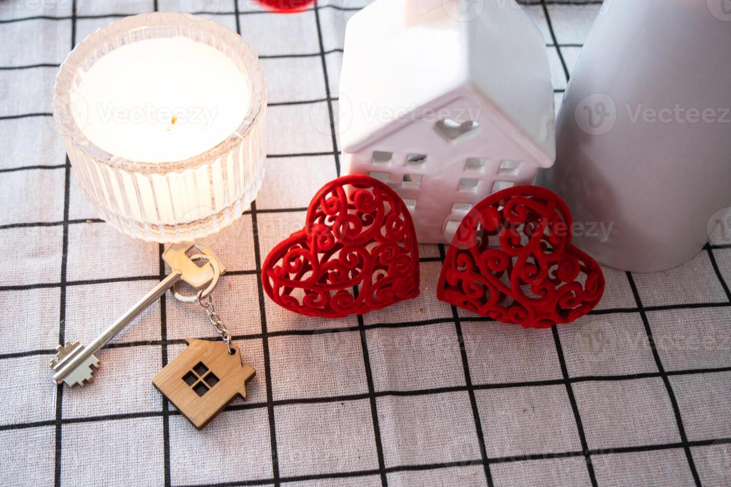 Schlüssel zu winzig Haus von gemütlich Zuhause mit Valentinstag Dekor auf Tabelle von Küche. Geschenk zum Valentinsgrüße Tag, Familie Liebe Nest. Design, Projekt, ziehen um zu Neu Haus, Hypothek, Miete und Kauf echt Nachlass foto