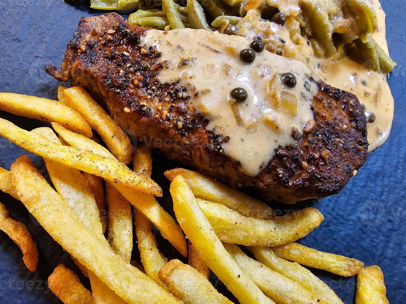 Französisch Pfeffersteak mit Grün Pfeffer Grün Bohnen und Pommes Pommes foto