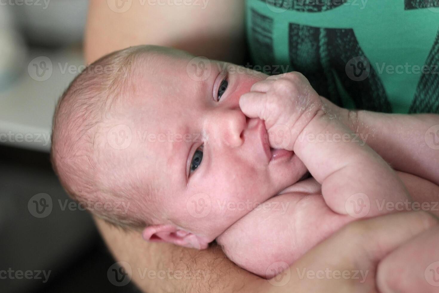 Porträt von ein Neugeborene Baby im das Waffen von Papa foto