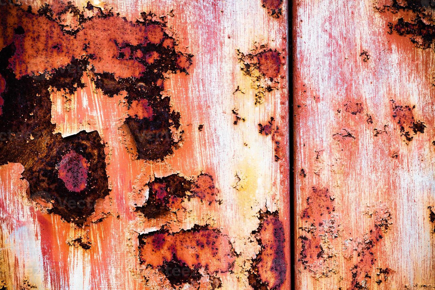 braune Grunge-Textur einer alten Metallwand mit Rost bedeckt. strukturierte Oberfläche mit interessantem Muster, schmutziges Blech mit abblätternder Farbe. verwitterte, raue und rostzerfressene Eisenwand der Garage. foto