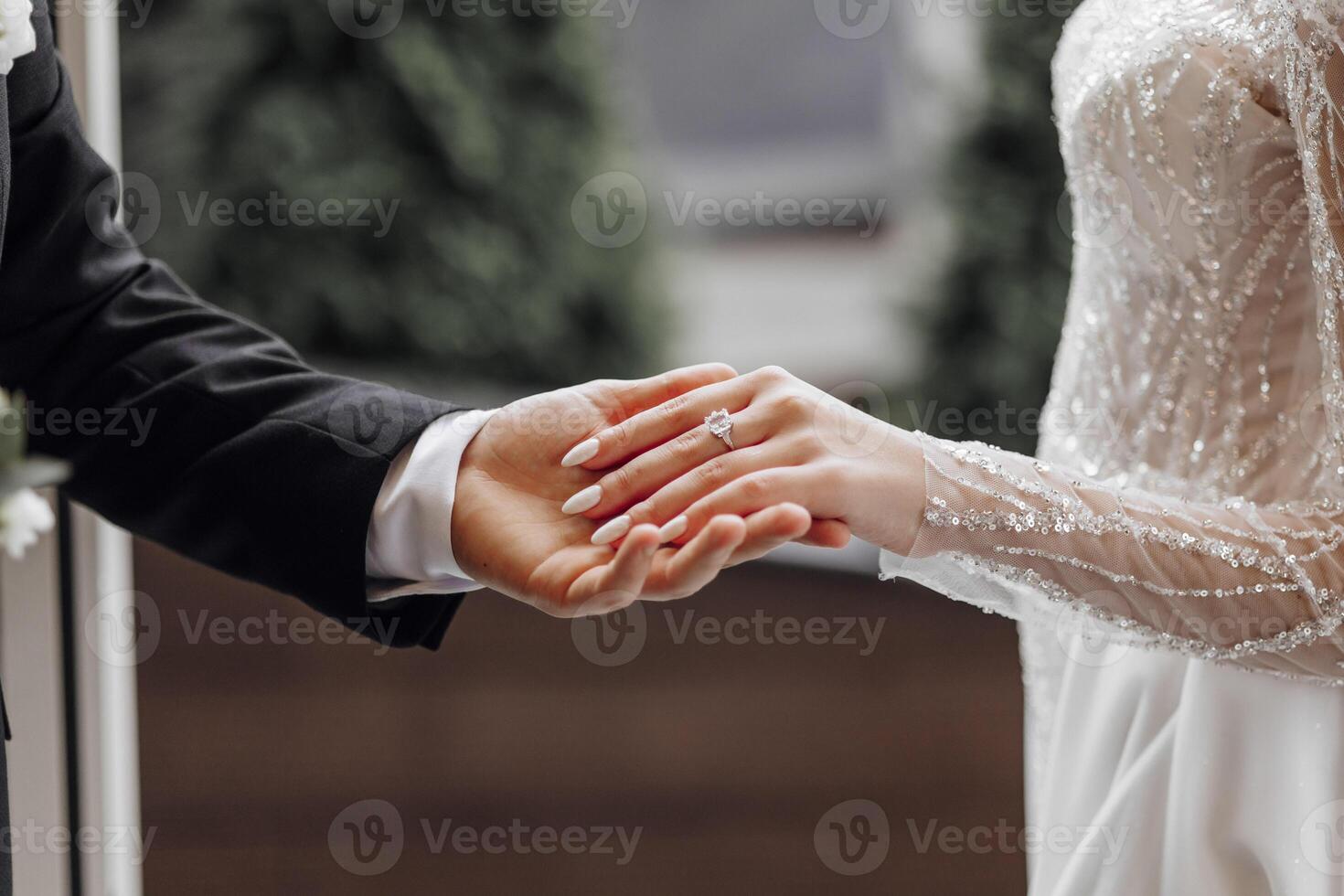 das Mann sanft hält das Braut Hand mit ein schön golden Hochzeit Ring. vergrößert Bild von Frischvermählte Hände. Hochzeit Konzept. das Bräutigam sanft berührt das Braut foto
