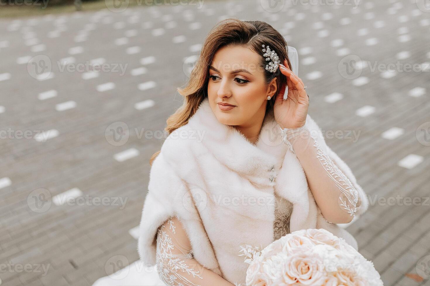 Porträt von ein schön Braut mit ein Hochzeit Strauß von Blumen, attraktiv Frau im ein Hochzeit Kleid mit ein lange Schleier. glücklich Braut Frau. Braut mit Hochzeit bilden und Frisur. Winter Hochzeit foto