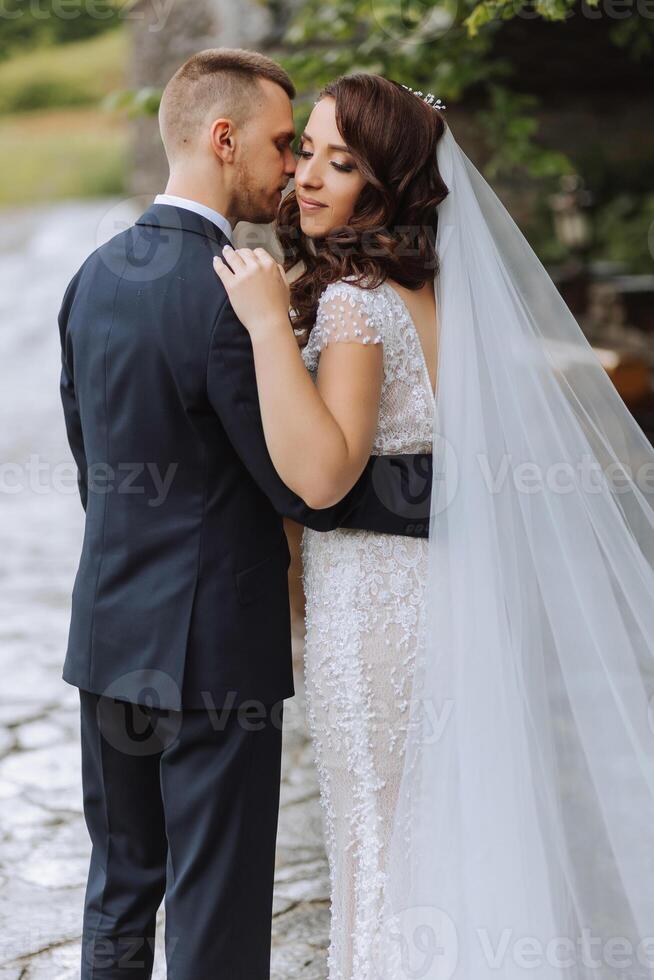 Hochzeit. Liebe und Paar im Garten zum Hochzeit. feiern das Zeremonie und Engagement. speichern das Datum. Vertrauen. das Bräutigam umarmt das Braut. zärtlich Küsse. Paar im Liebe. Rückseite Sicht. foto