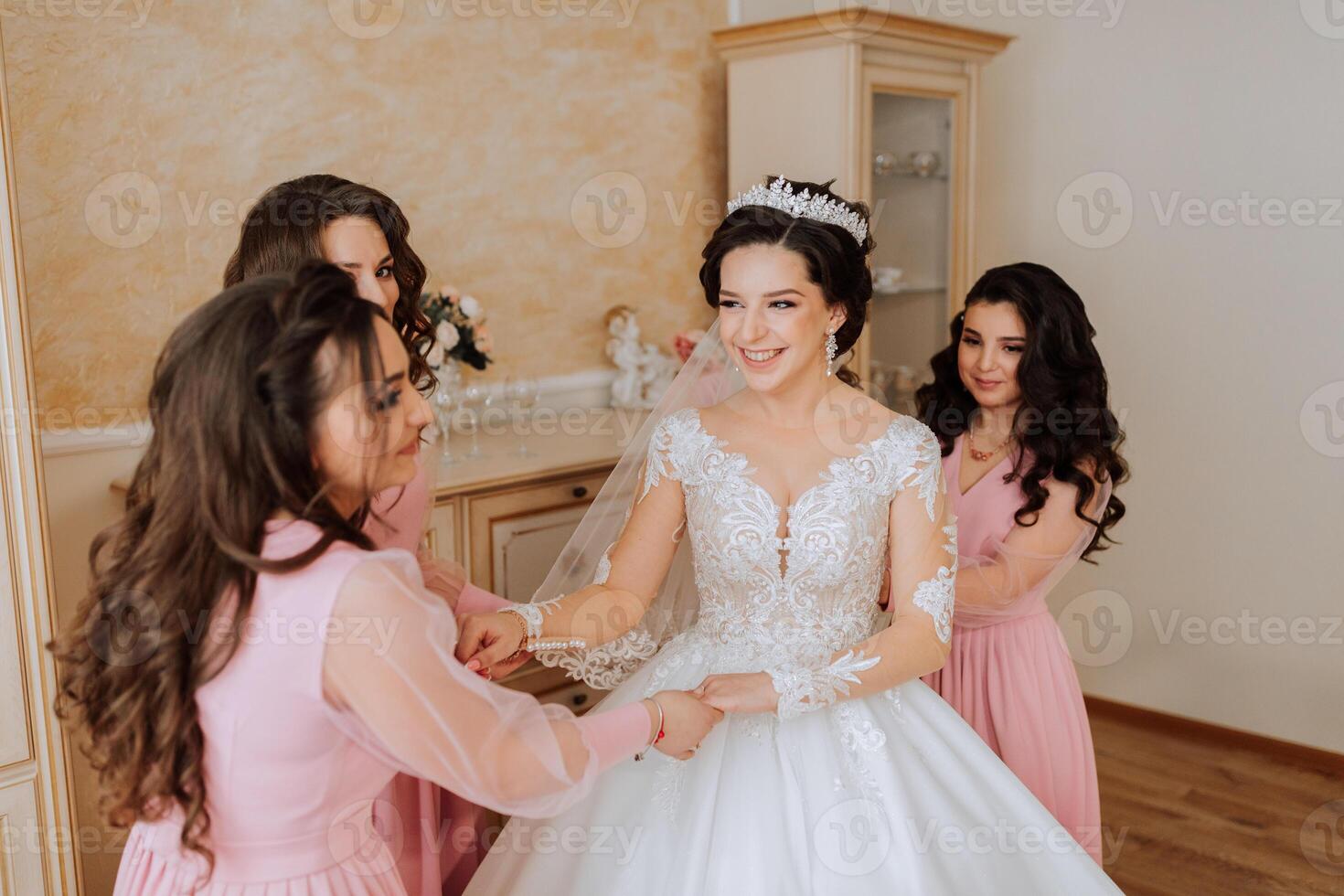 ein Freund hilft das Braut befestigen ihr Kleid. ein Frau hilft ihr Freund befestigen das Tasten auf das zurück von ihr Hochzeit Kleid. das Morgen von das Braut, das Schaffung von ein Familie, ein wichtig Fall. foto