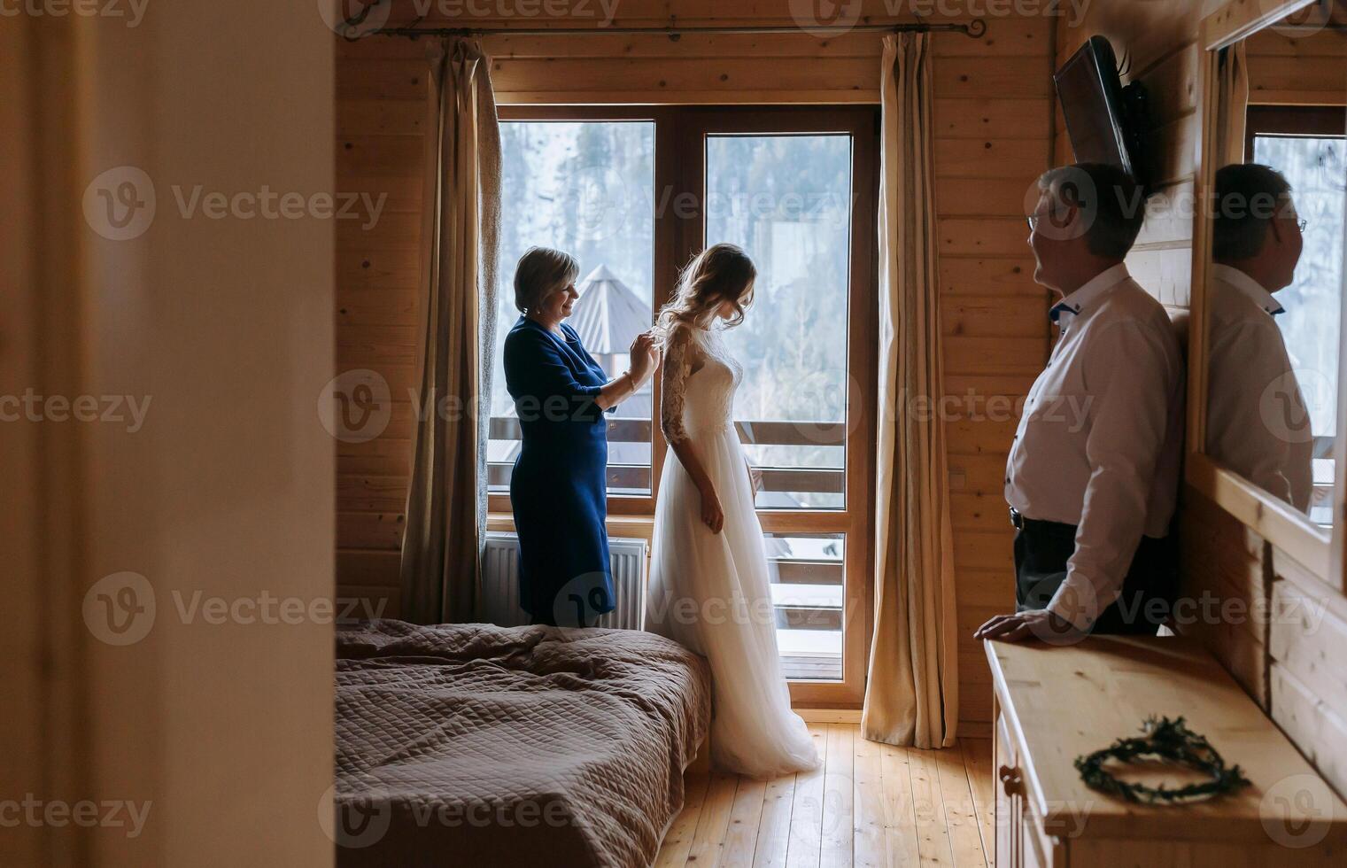 Foto mit Eltern beim das Hochzeit. glücklich Eltern Hilfe und jubeln zum ihr bald verheiratet sein Tochter. berühren Momente beim das Hochzeit. Mutter Bindungen das Kleid von ihr Tochter Braut