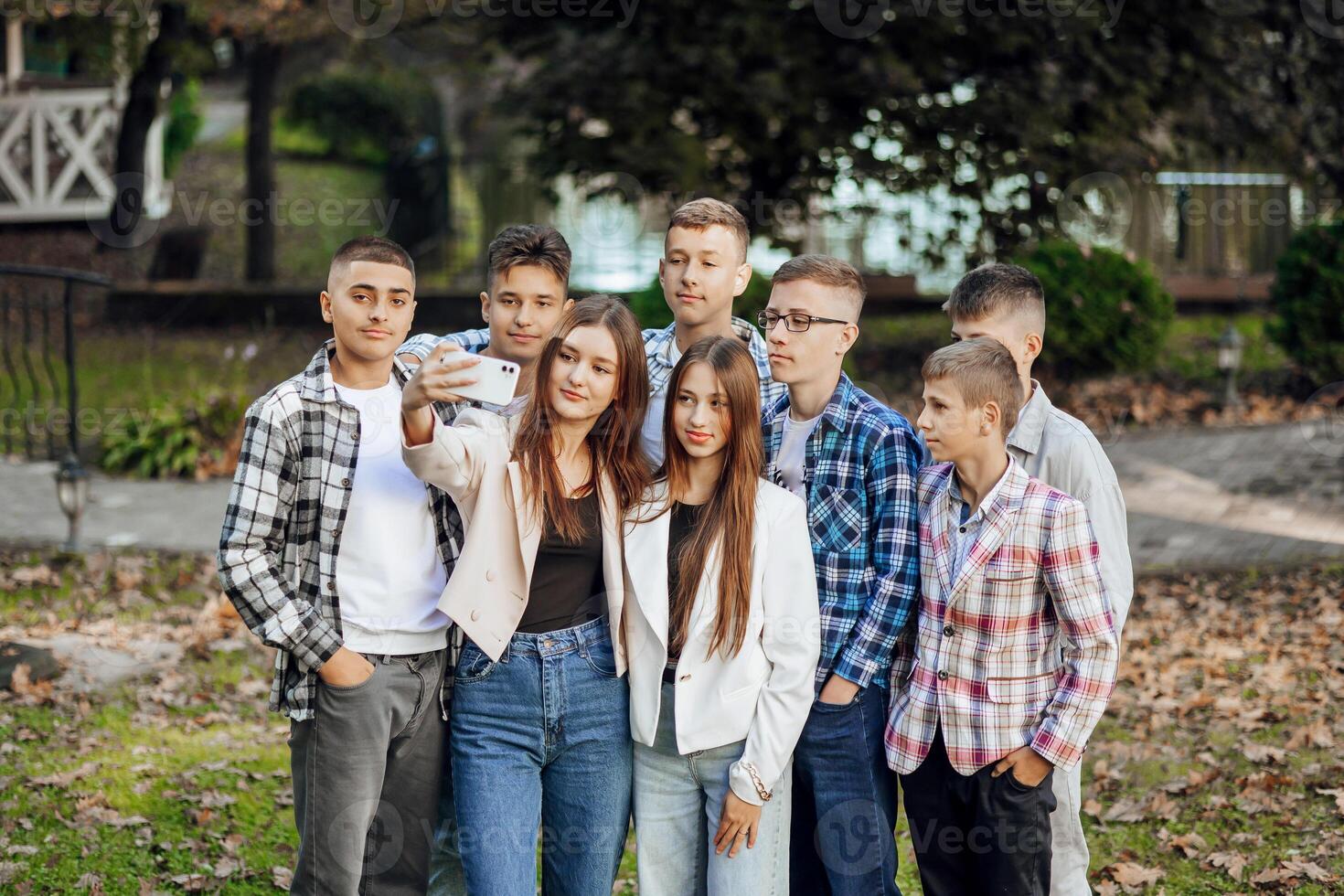 freunde nehmen ein groß Gruppe Selfie lächelnd beim das Kamera - - Lachen jung Menschen Stehen draußen und haben Spaß - - Porträt von heiter Schulkinder draußen Schule - - Mensch Ressourcen Konzept foto