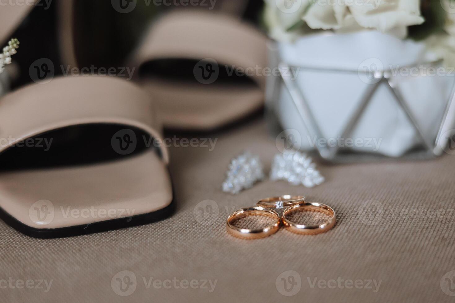 Einzelheiten von das Braut. Schönheit ist im das Einzelheiten. hochhackig Braut- Schuhe. Gold Hochzeit Ring mit ein Diamant. Parfums. Ohrringe Hochzeit im Einzelheiten. foto