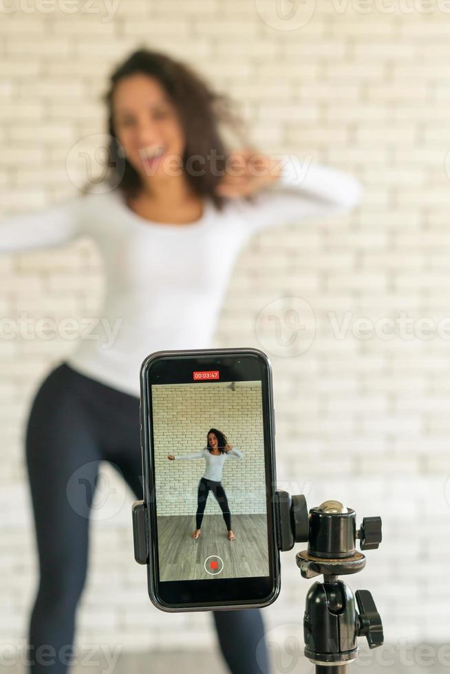 Latin Woman hat ihr Tanzvideo mit der Smartphone-Kamera erstellt. um Videos an Social-Media-Anwendungen zu teilen. foto