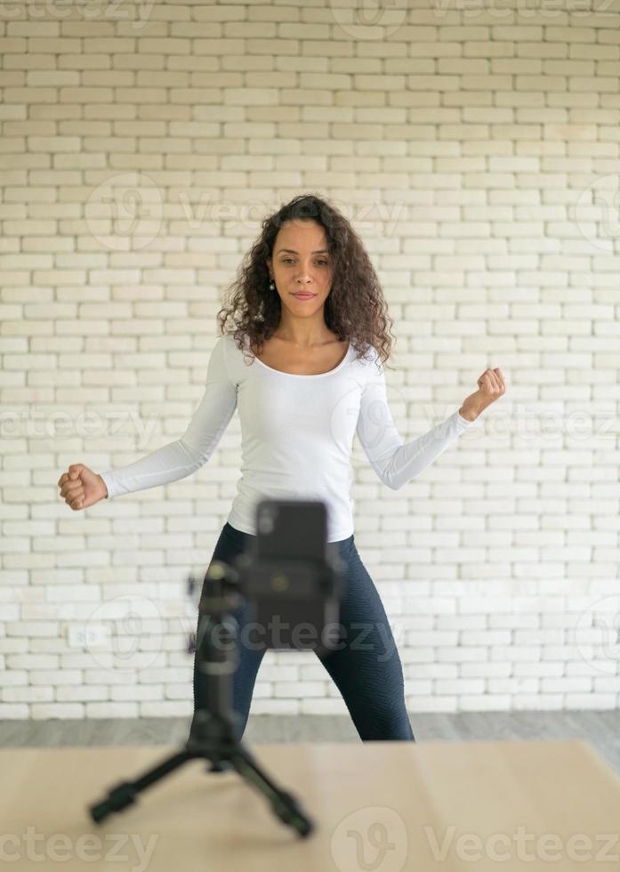 Latin Woman hat ihr Tanzvideo mit der Smartphone-Kamera erstellt. um Videos an Social-Media-Anwendungen zu teilen. foto