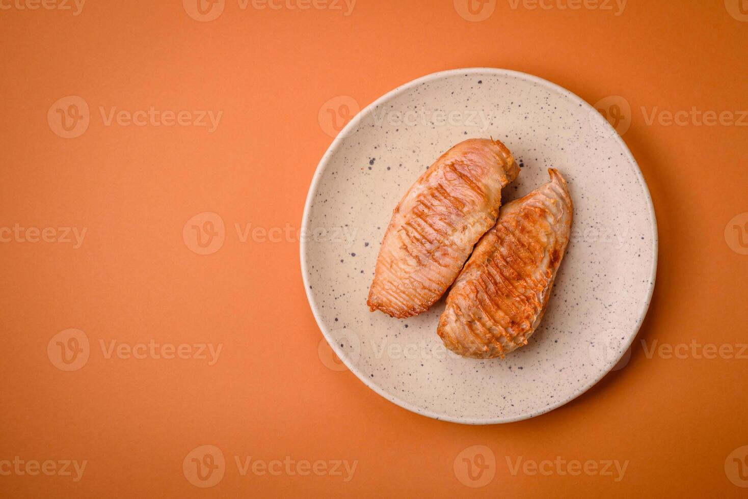 Köstliches frisch gegrilltes Hähnchenfilet mit Gewürzen und Kräutern auf dunklem Betonhintergrund foto