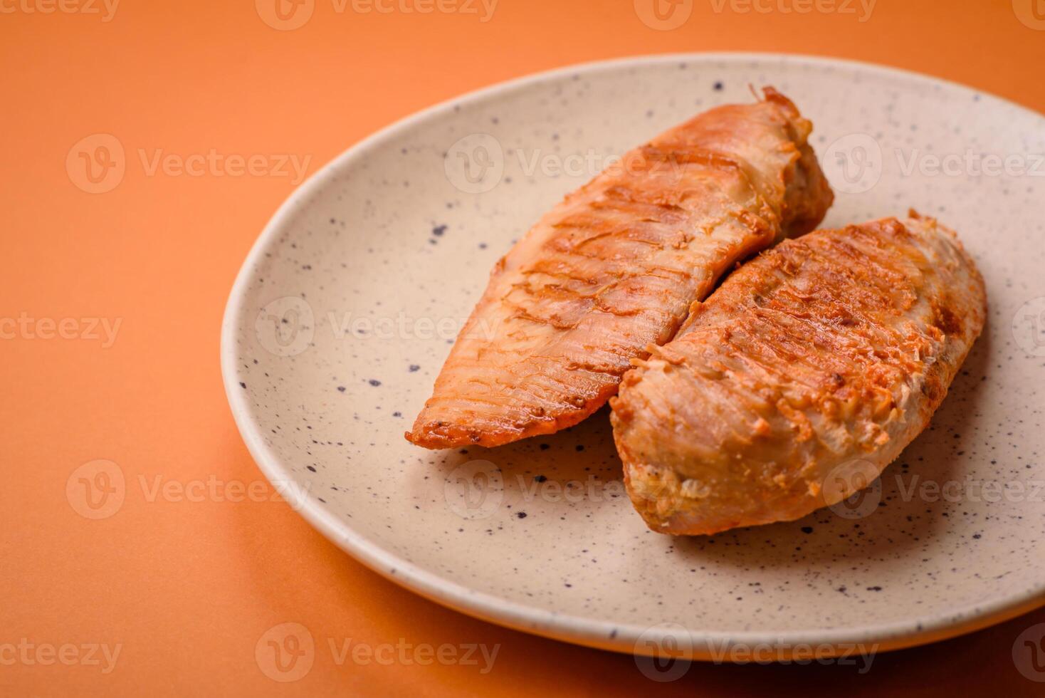 Köstliches frisch gegrilltes Hähnchenfilet mit Gewürzen und Kräutern auf dunklem Betonhintergrund foto