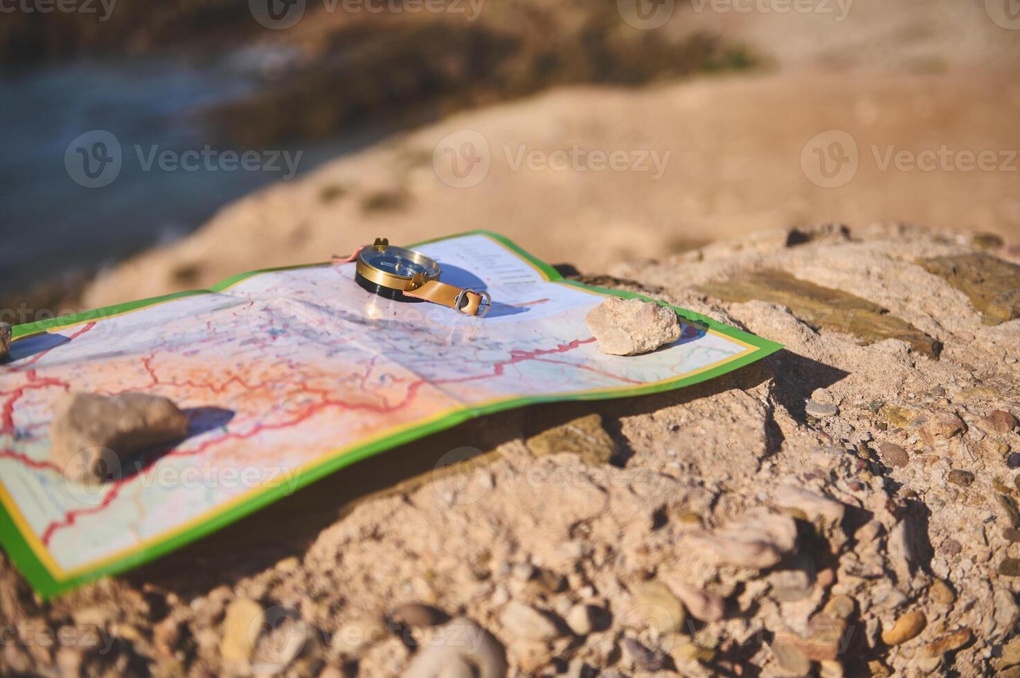 geografisch Karte und nautisch Ausrüstung Kompass auf ein Felsen gegen das Hintergrund von ein Cliff mit Blick auf das atlantisch Strand foto