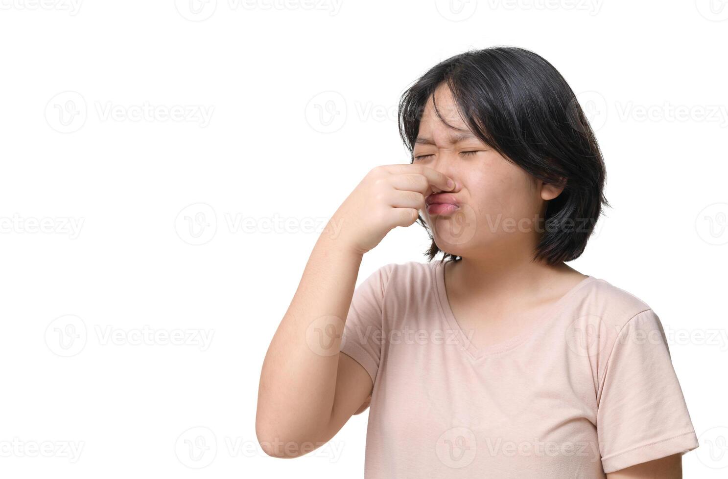 süß Mädchen tragen ein Rosa T-Shirt Abdeckungen ihr Nase mit ihr Hand weil riecht schlecht. foto