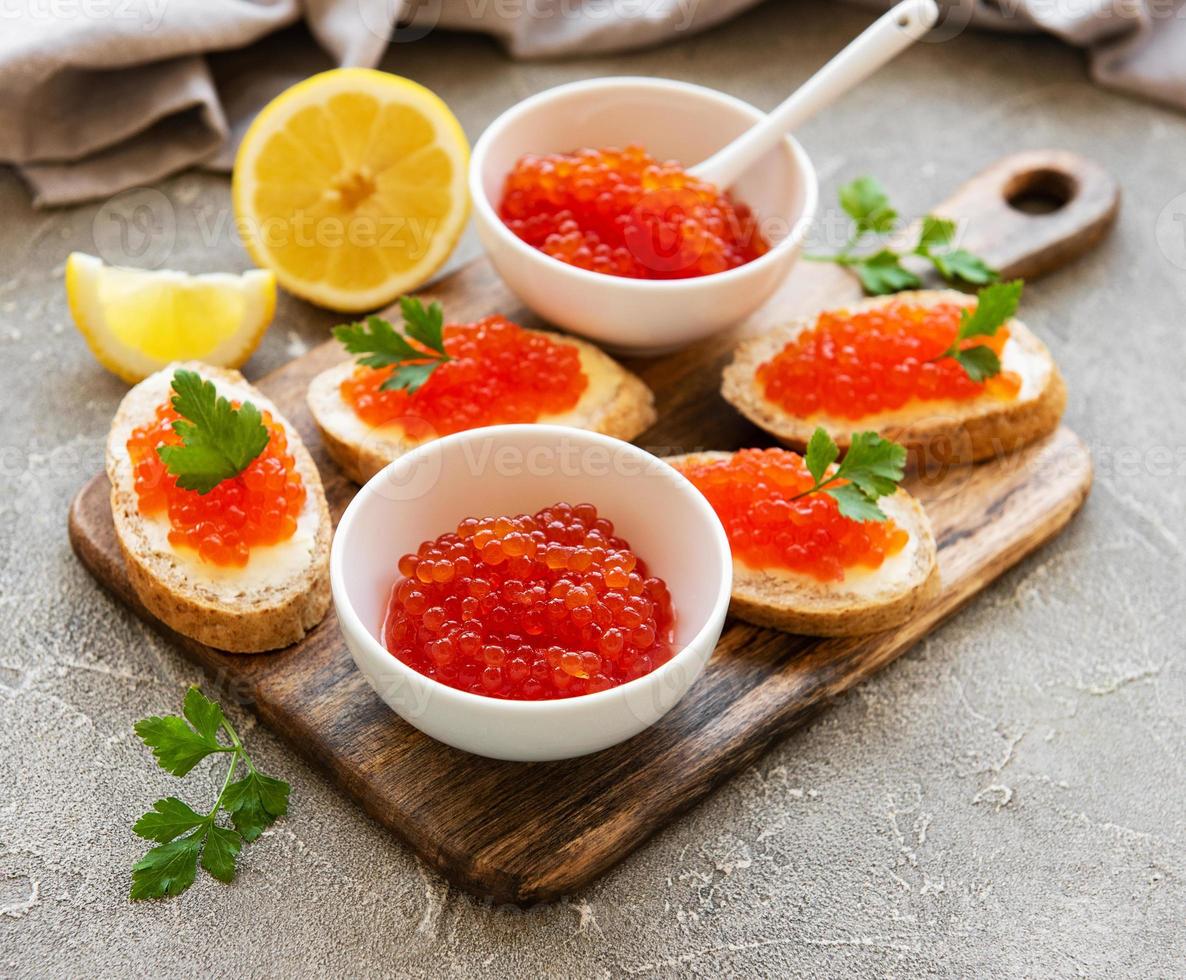 roter Kaviar in Schüssel und Sandwiches foto