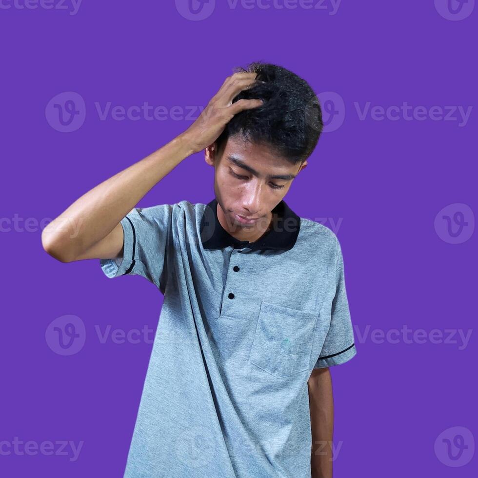 schwindlig Gesicht halten Kopf von asiatisch jung Mann im grau T-Shirt. isoliert auf Gelb Hintergrund foto